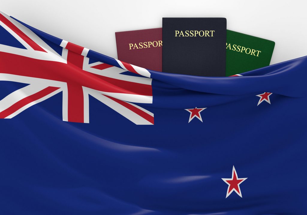 New Zealand flag with passports behind it